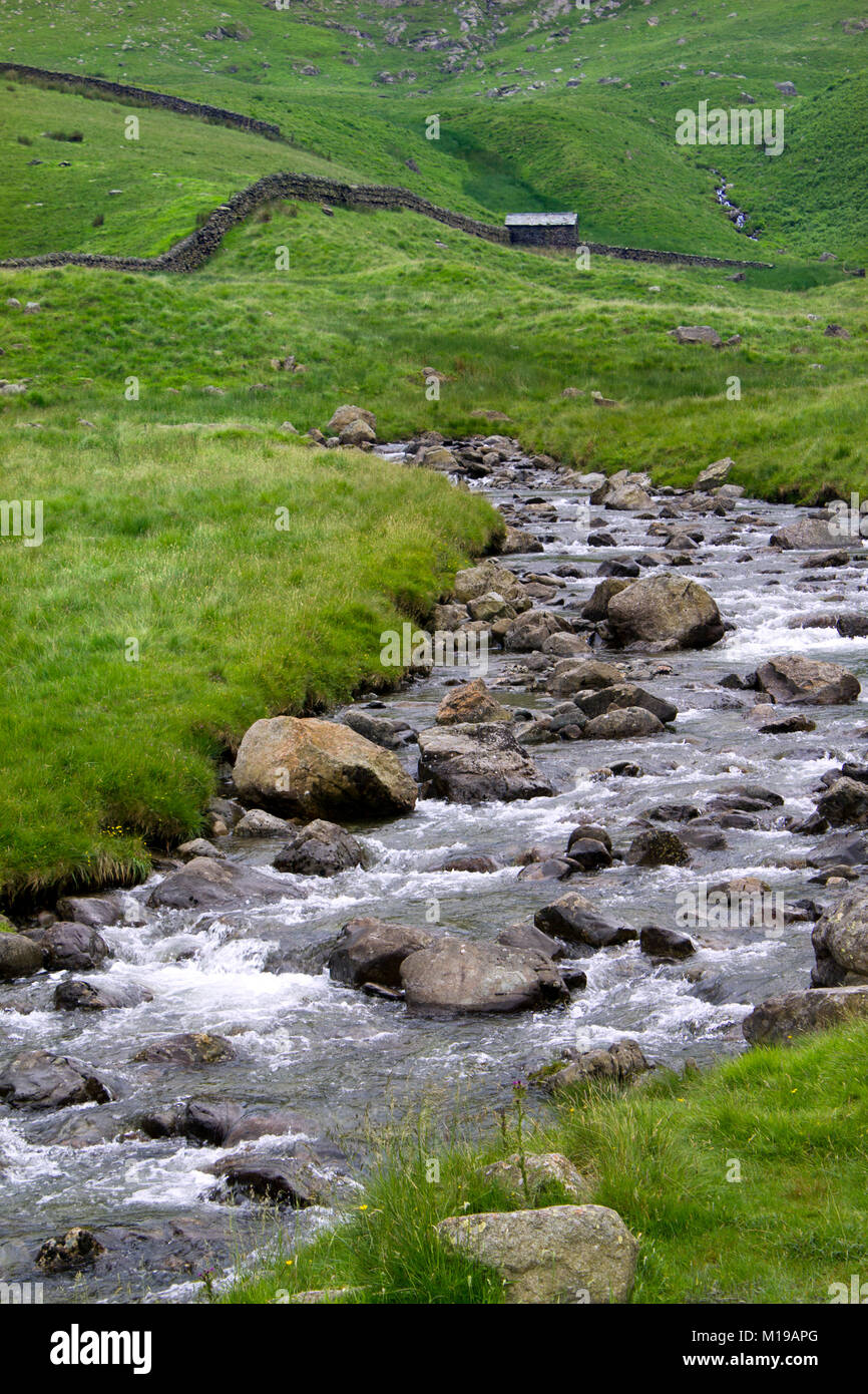 Un pittoresco torrente di montagna e tipica vecchia capanna e stalattite pareti in prossimità della testa del Scafell serbatoio in Mardale valley, Cumbria, Regno Unito Foto Stock