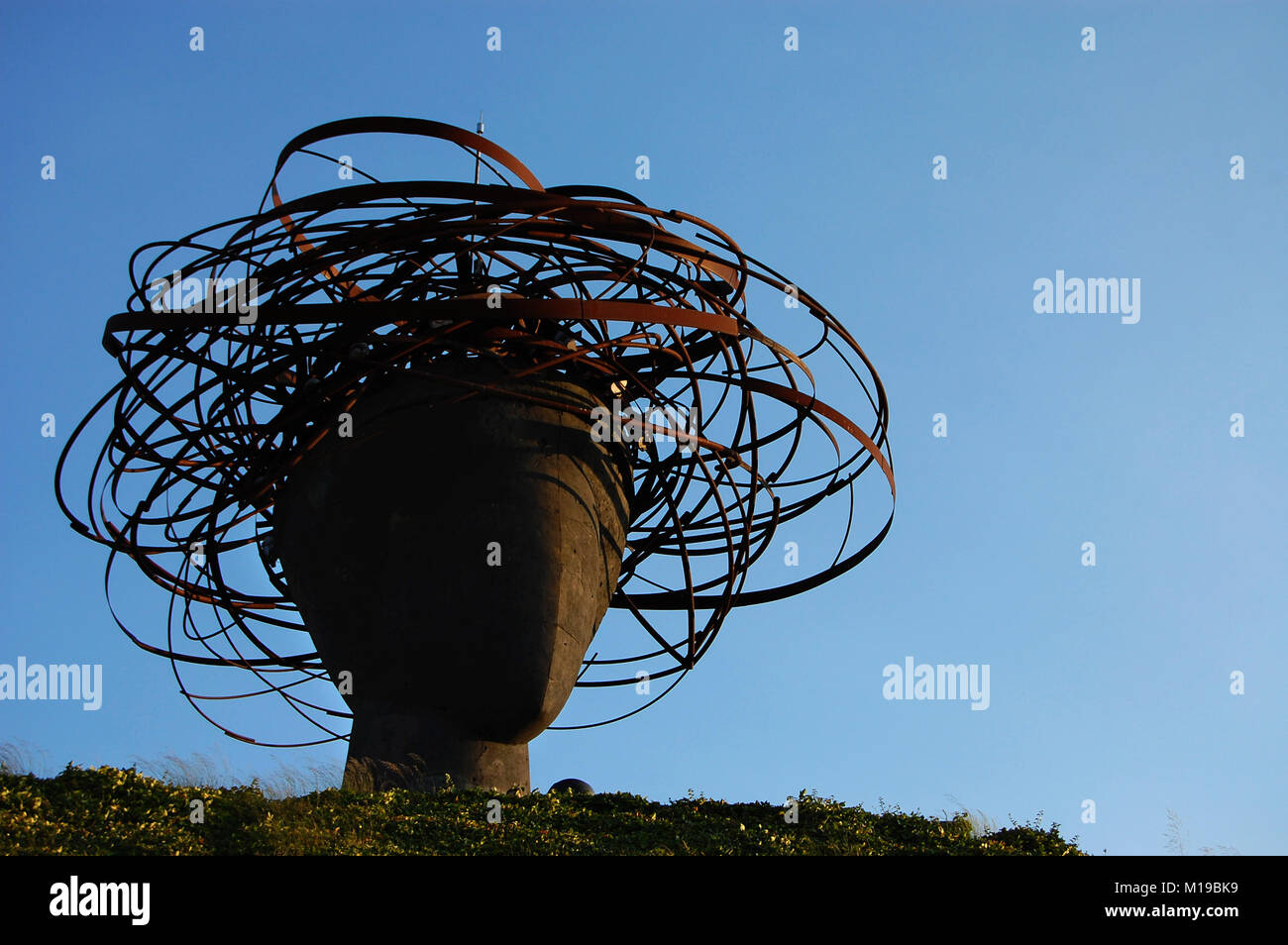 Testa di ferro scultura con copricapo in un parco con il cielo in background Foto Stock