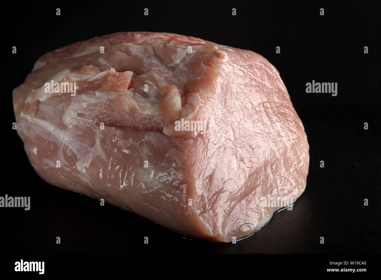 Pezzo di crudo fresco di carne di maiale - lombata su ardesia scura Foto Stock