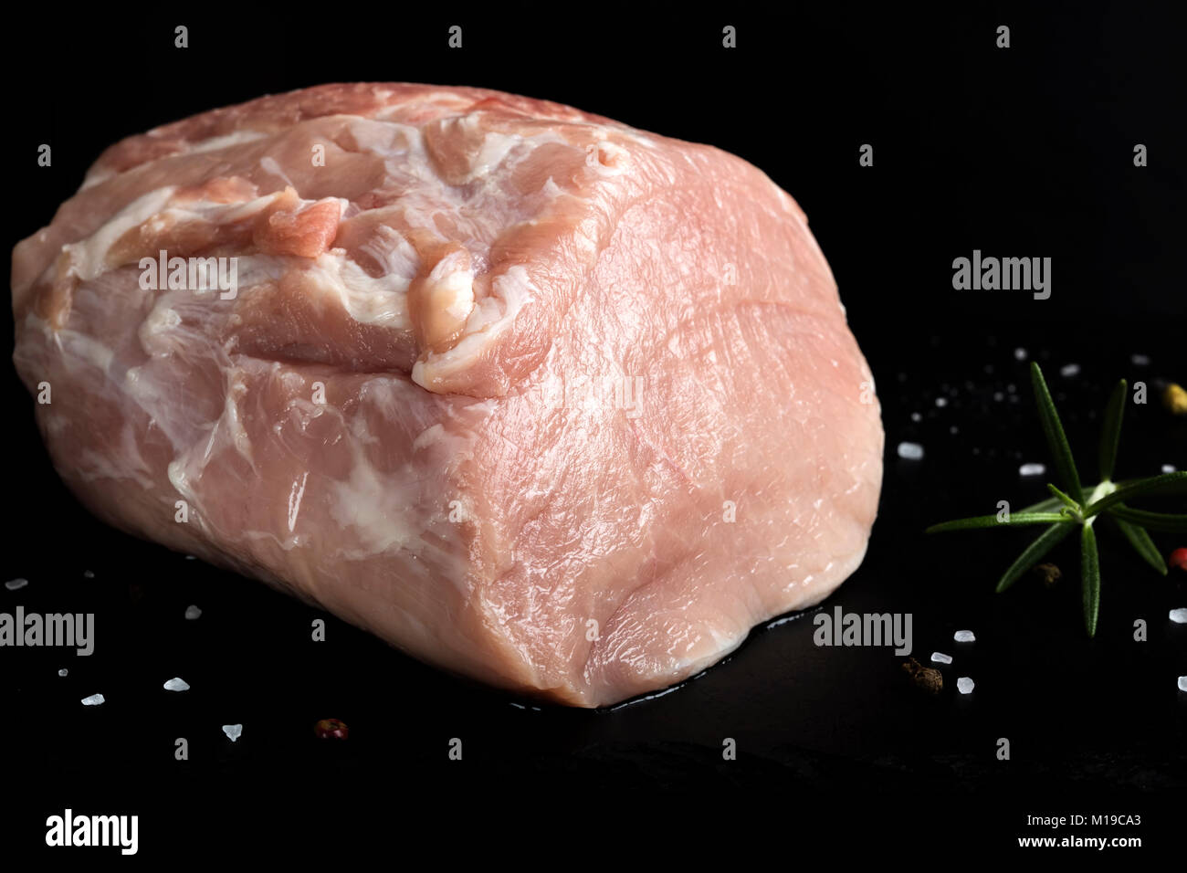 Pezzo di crudo fresco di carne di maiale - la lombata con spezie su ardesia scura Foto Stock