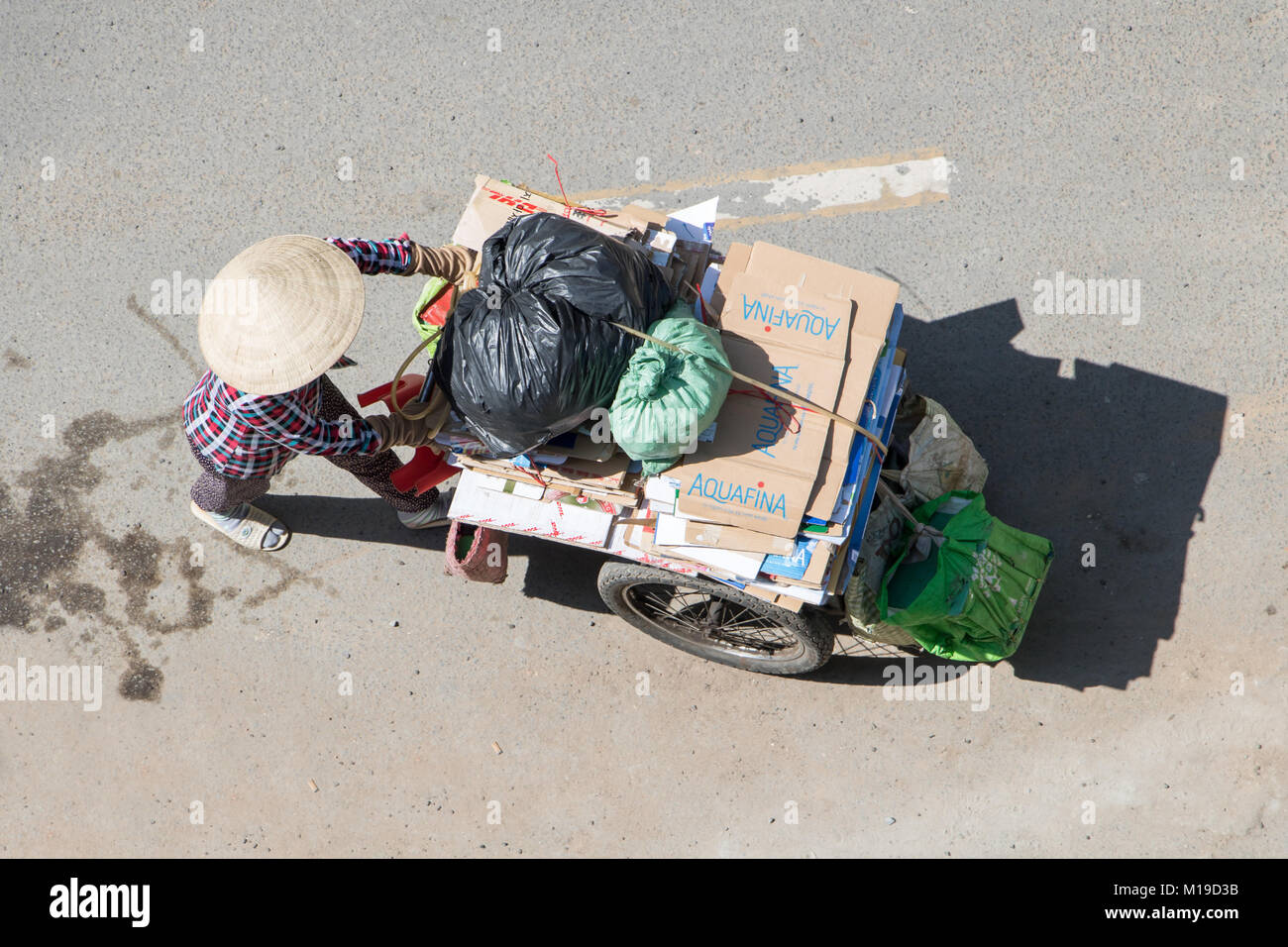 A Saigon, Vietnam, DIC 17 2017, la raccolta di rifiuti riciclabili per le strade della città di Ho Chi Minh. Donna vietnamita spingendo un carrello pieno di borse, Saigon Foto Stock