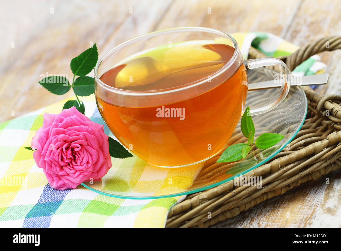 Tazza di tè e rosa rosa sul vassoio di vimini Foto Stock