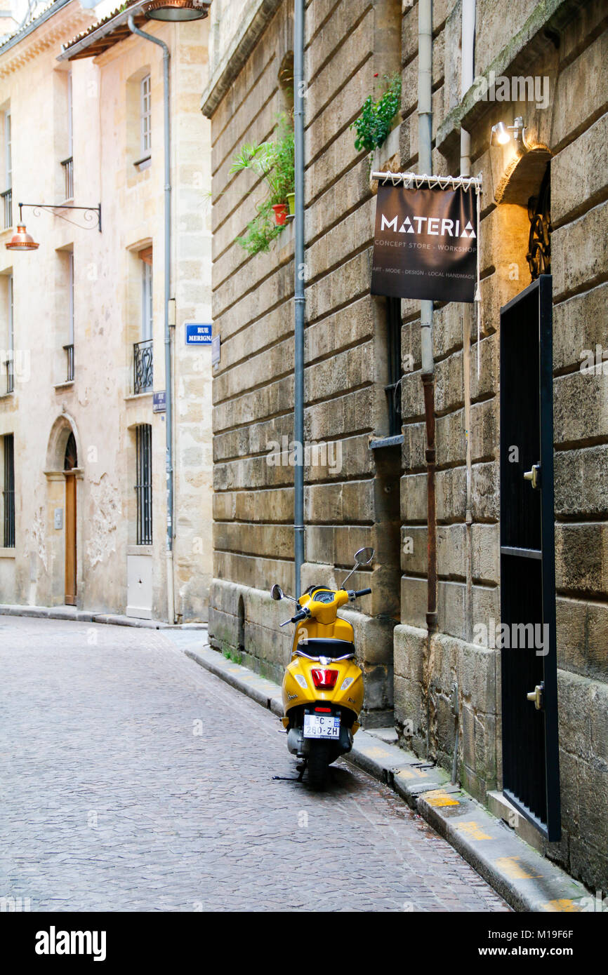 Giallo scooter parcheggiato su rue du Puits Descujols, Bordeaux, Gironde, Nouvelle-Aquitaine, Francia. Foto Stock