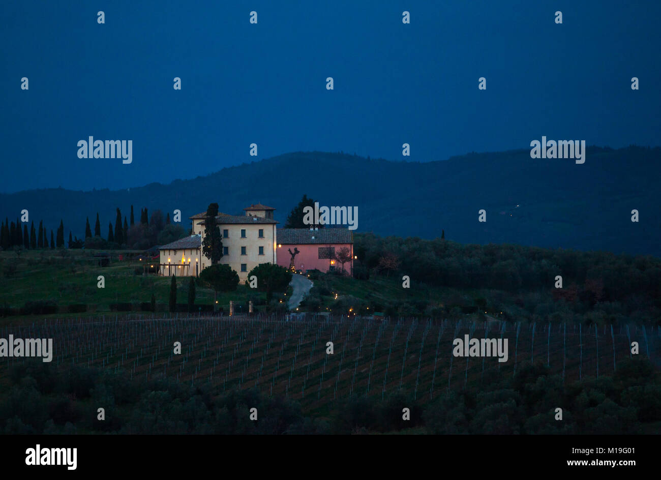 Il paesaggio toscano e strada di campagna con cipressi, alberi e palazzi antichi. Regione Toscana in Italia. Foto Stock