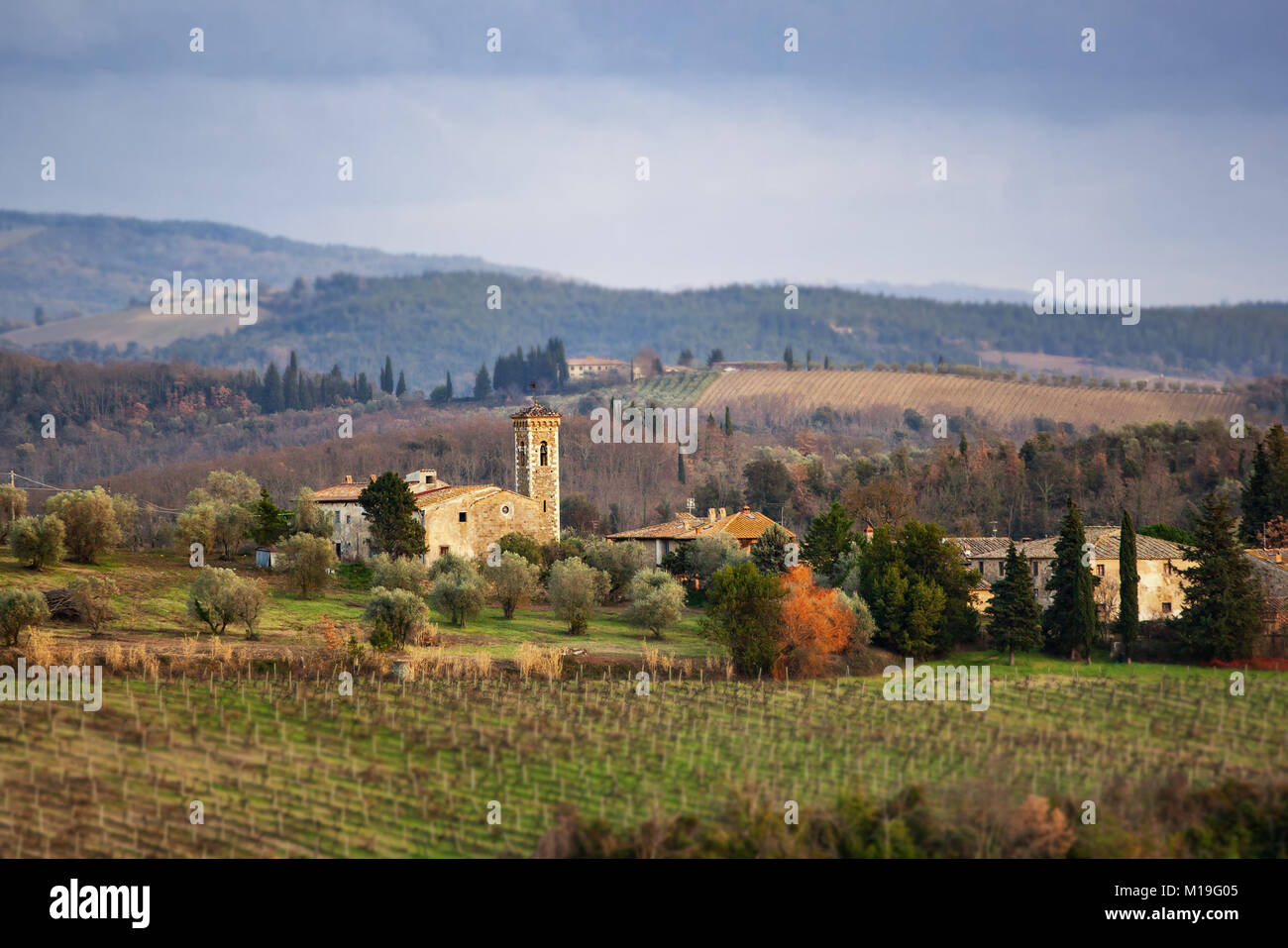 Il paesaggio toscano e strada di campagna con cipressi, alberi e palazzi antichi. Regione Toscana in Italia. Foto Stock
