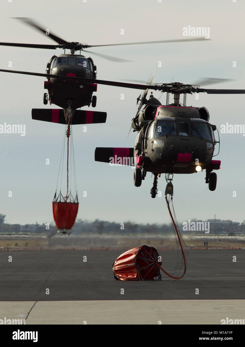 Una coppia di California la Guardia Nazionale UH-60 Black Hawk elicotteri da B Company, 1° Battaglione, centoquarantesimo reggimento di aviazione, tornare a Camarillo Airport in Camarillo, California, Domenica, Dicembre 10, 2017, dopo la realizzazione di gocce di acqua su Thomas fuoco nella Contea di Ventura. (U.S. Air National Guard foto di Senior Airman Crystal Housman) Foto Stock