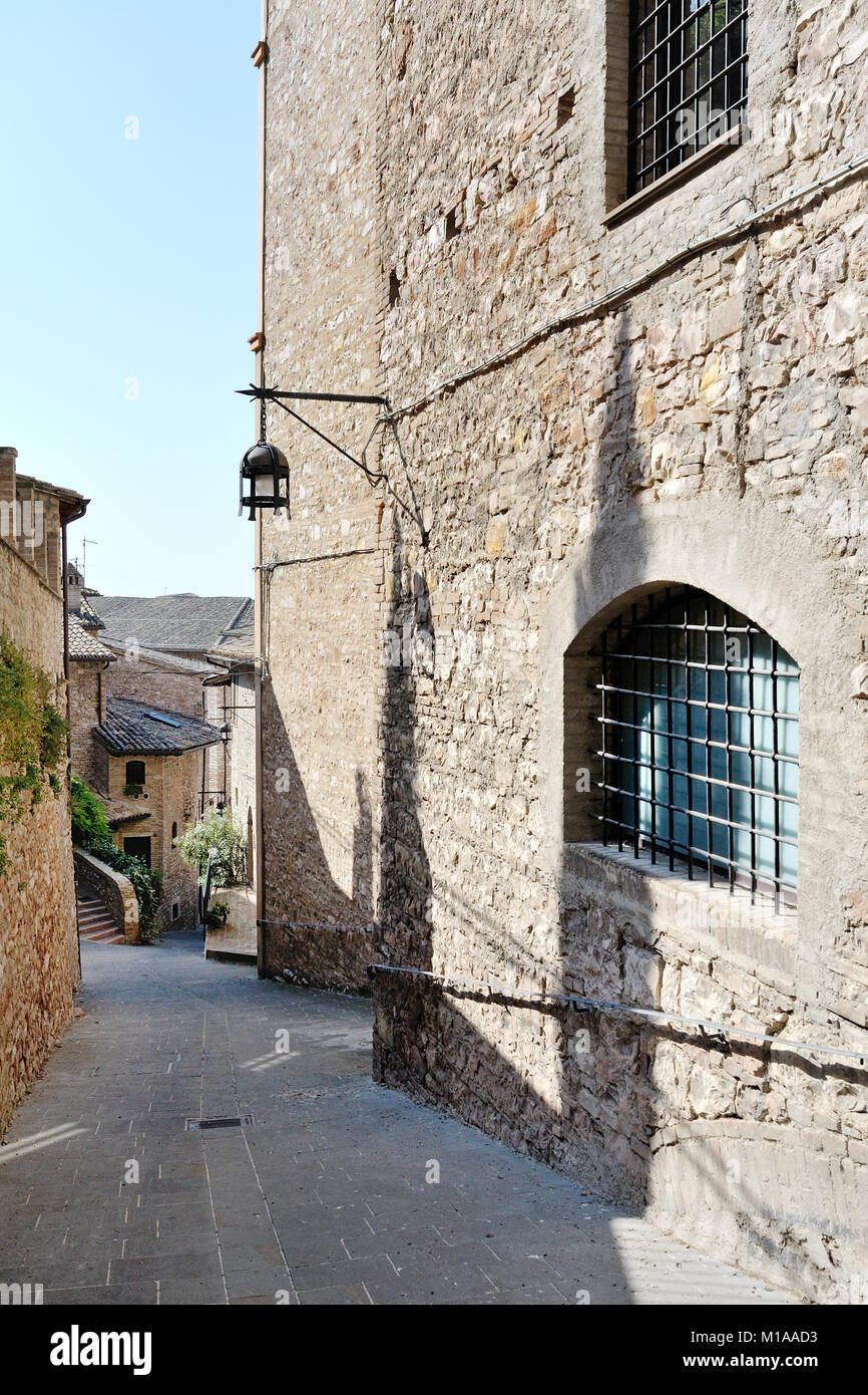 Via medievale italiano nella città sulla collina di Assisi. La tradizionale italiano medievale centro storico in Umbria. Italia Foto Stock