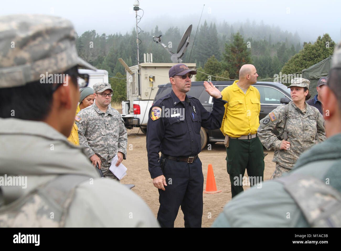 Michael Steineke, CAL del fuoco di collegamento militare alla Task Force alfa, California Army National Guard, fornisce la mattina breve il Agosto 9 in corrispondenza di Anguilla River Conservation Camp in Redway, California. Più di 200 truppe trascorso diversi giorni a Humboldt fulmini fuoco base camp eseguendo mop fino dazi, impedendo future wildfire flare ups. (U.S. Esercito nazionale Guard foto/Staff Sgt. Eddie Siguenza.) Foto Stock