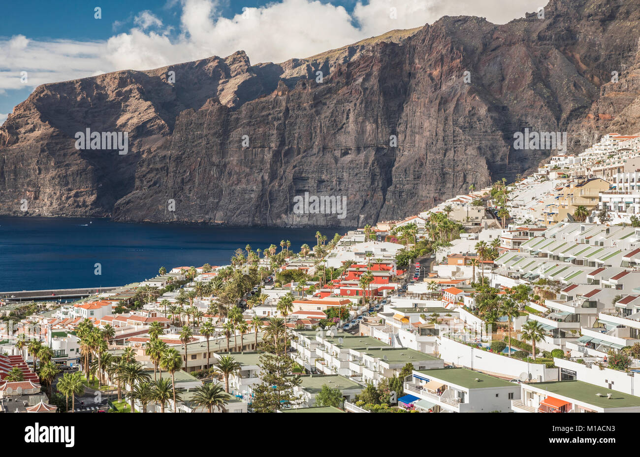 Il Centro Turistico Città di Los Gigantes, Tenerife, Isole Canarie, con le famose scogliere gigante dal quale la città prende il suo nome in background, Foto Stock