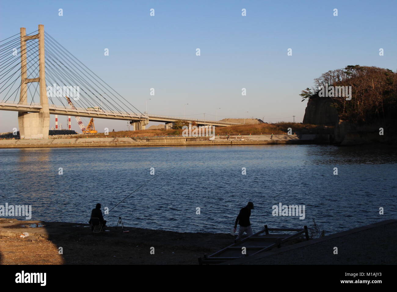 4 Novembre 2015 , Soma, Fukushima, Giappone, 2 uomini a pesca di Porto Matsukawaura, Soma city, Fukushima. Il ponte sulla laguna era chiuso per 6 anni dopo la catastrofe Tsunami-Earthquake 2011. Foto Stock