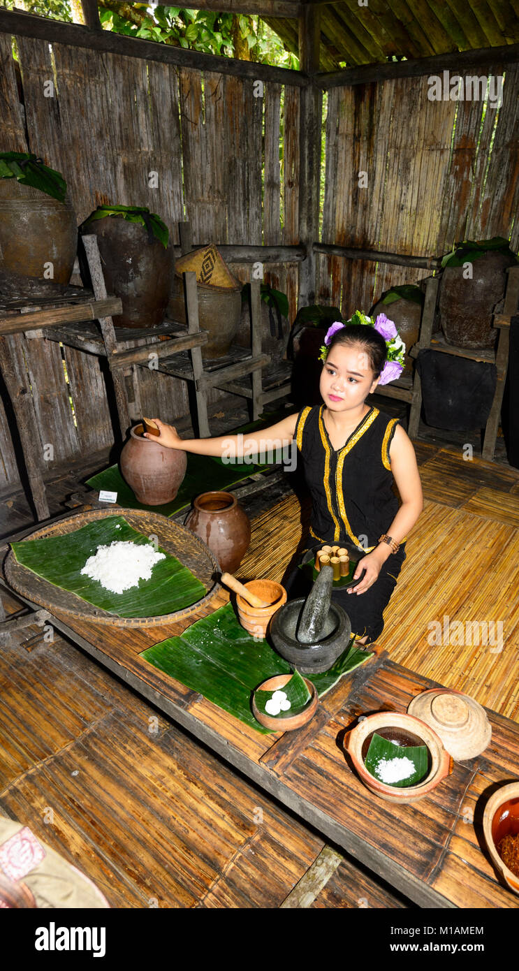 Piuttosto giovane donna che offre cibo tradizionale dei campioni a Mari Mari Villaggio Culturale, Kota Kinabalu, Sabah Borneo, Malaysia Foto Stock