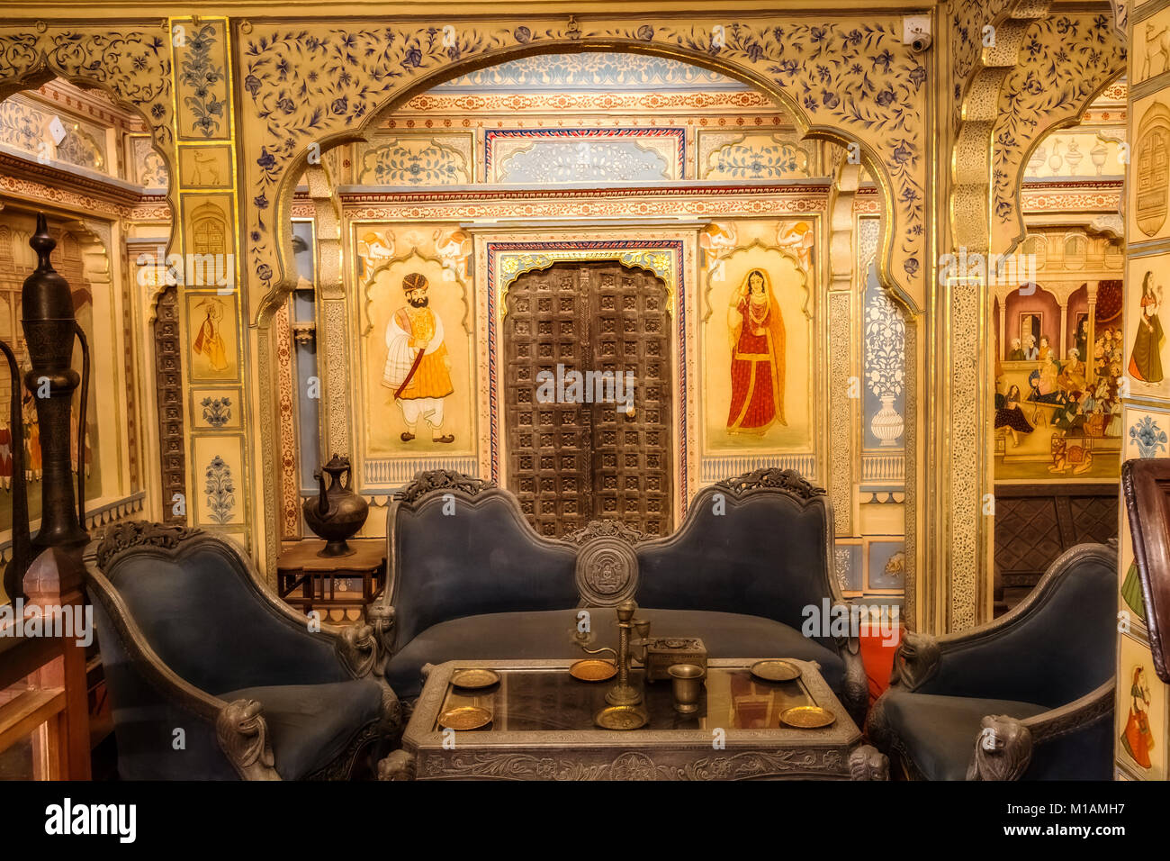 Rajasthani opera d'arte wall art dipinti del palazzo reale camera con mobili antichi all'heritage building Patwon Ki Haveli a Jaisalmer Rajasthan. Foto Stock