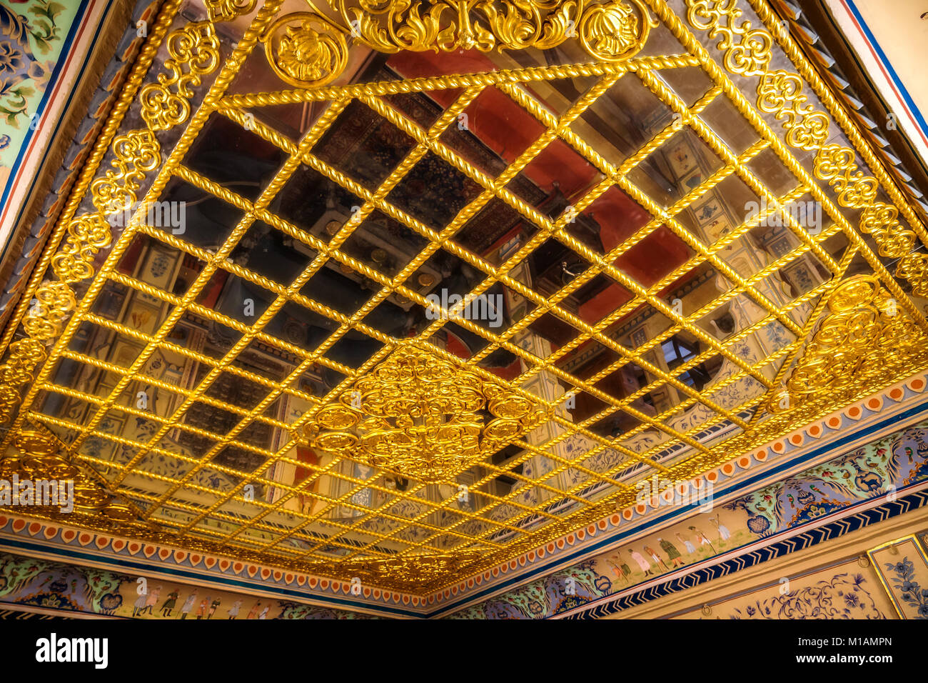 Royal Palace stanza a soffitto Patwon Ki Haveli Jaisalmer con intricati lavori artistici in oro e specchi. Foto Stock