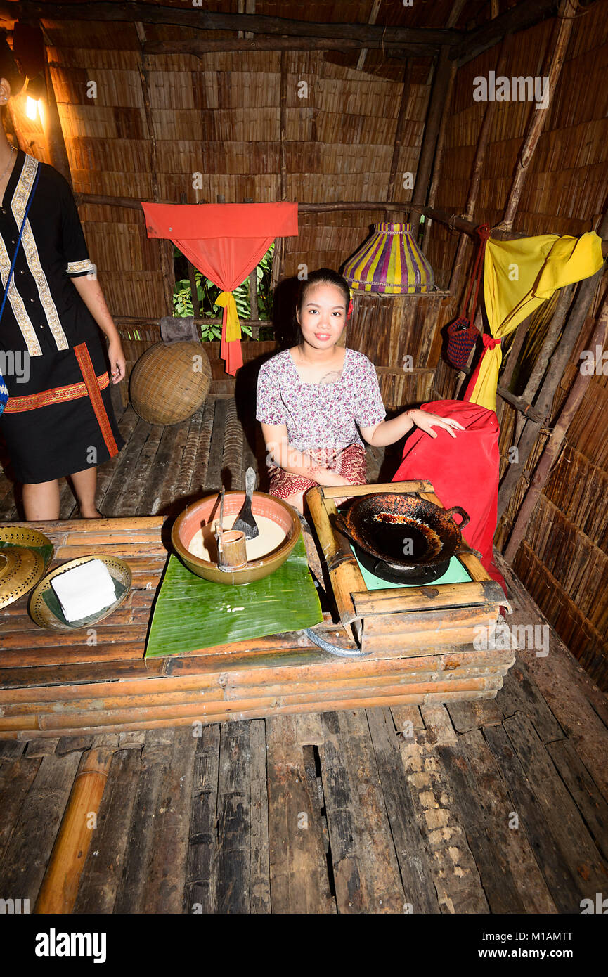 Piuttosto giovane donna malese cucinare frittelle a Mari Mari Villaggio Culturale, Kota Kinabalu, Sabah Borneo, Malaysia Foto Stock