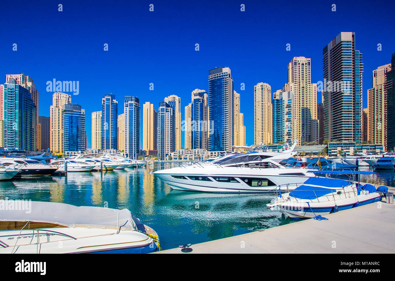 Dubai sunny cityscape. Cielo blu chiaro su grattacieli. Yacht di lusso in marina nel centro cittadino di Dubai. Foto Stock