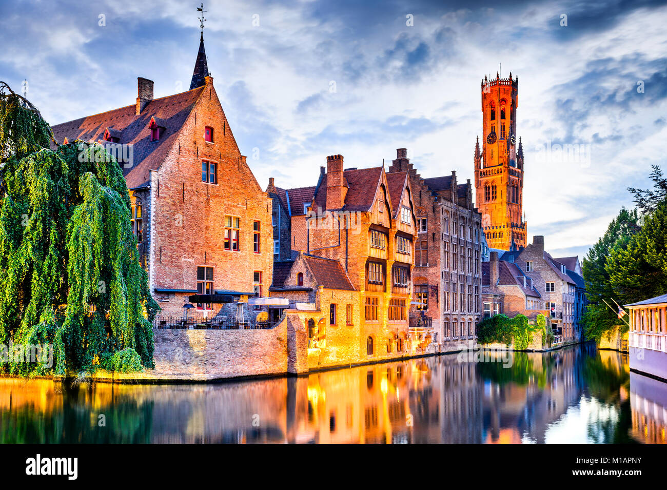 Bruges, Belgio. Immagine con Rozenhoedkaai in Brugge, Dijver fiume canal crepuscolo e la torre campanaria (Belfort) torre. Foto Stock