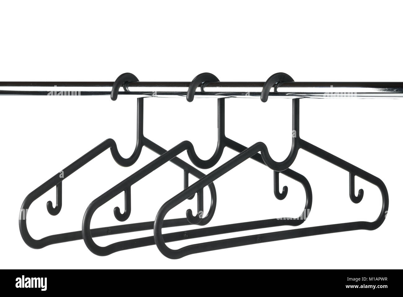 Tre nera vuota di rivestimento di plastica / appendiabiti su un bastone appendiabiti con uno sfondo bianco. Copia di potenziale spazio sopra appendiabiti. Foto Stock