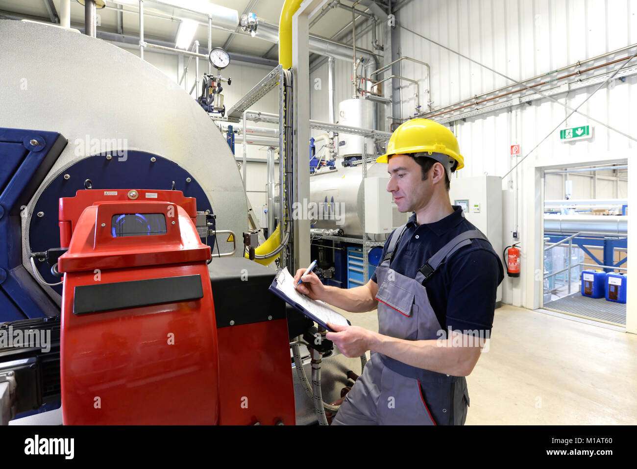 I lavoratori in un impianto industriale di verificare i sistemi con la tecnologia moderna Foto Stock