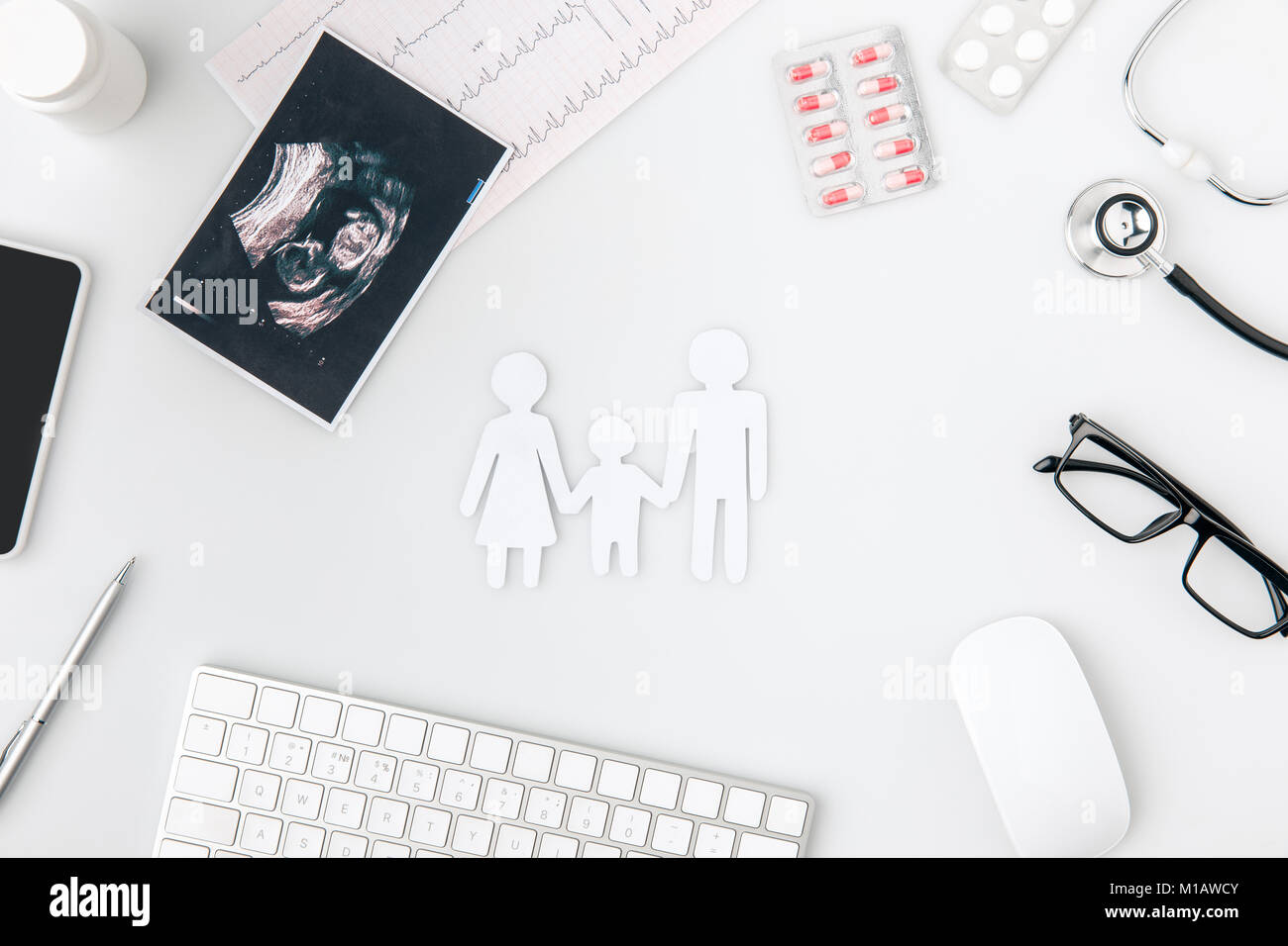 Silhouette bianca della famiglia circondato da pillole, keboard, foto, vetri isolati su sfondo bianco Foto Stock