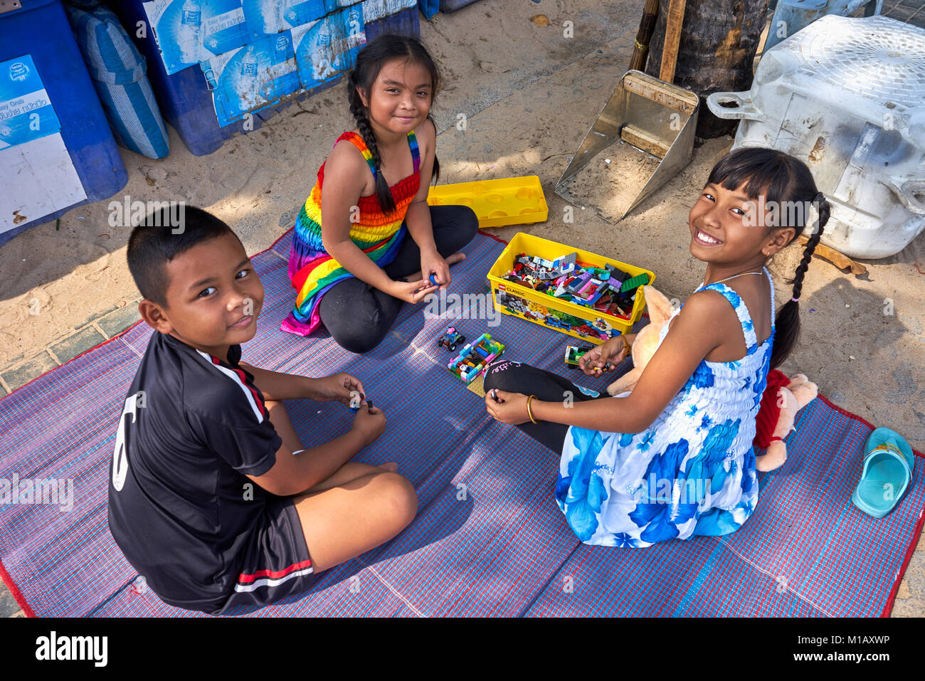 Bambini che giocano all'aperto con un set Lego. Thailandia scena di strada del Sud-Est asiatico. Foto Stock