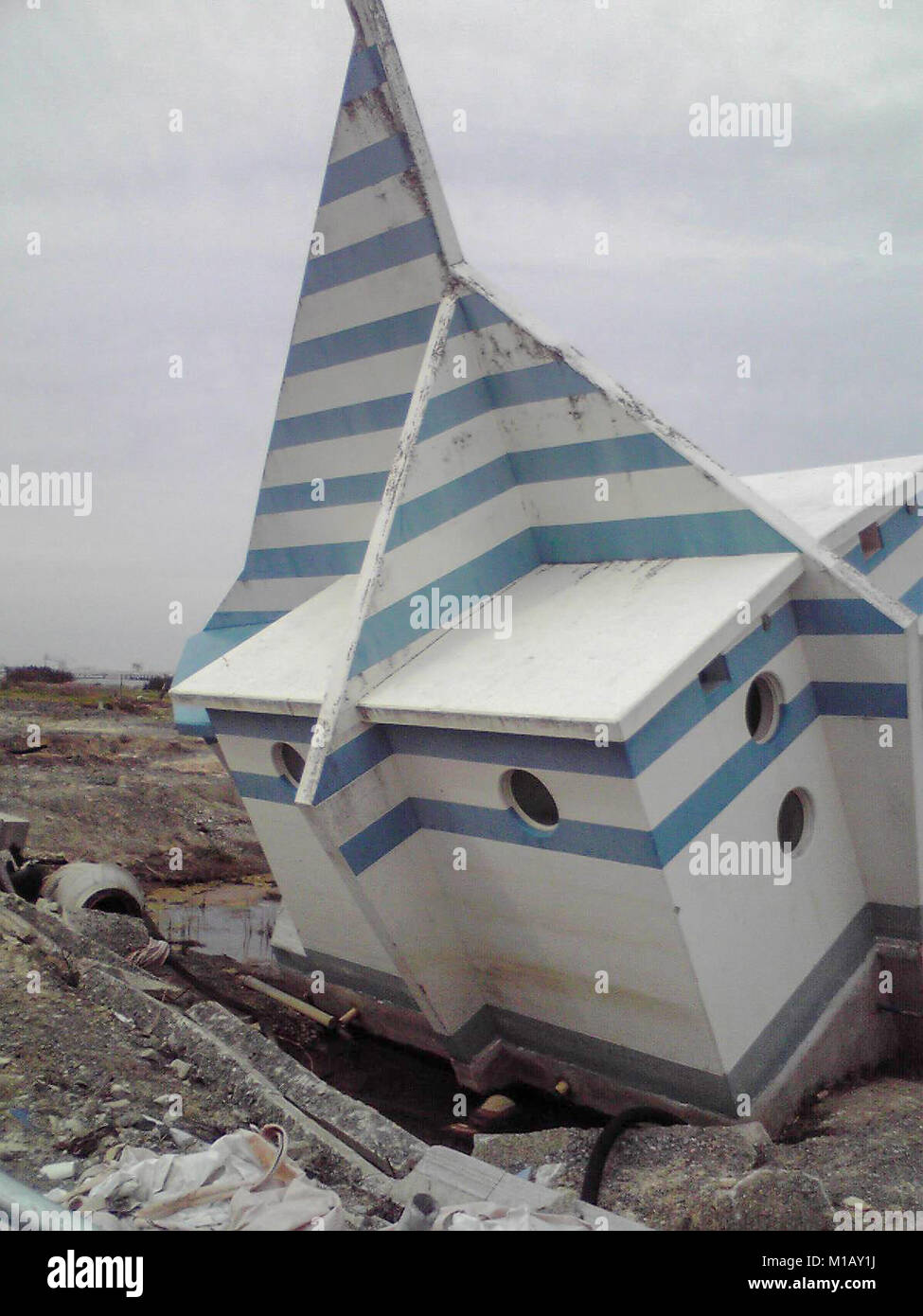 2 marzo 2012, Soma, Fukushima, Giappone. Quasi 1 anno dopo il Tohoku Earthquake-Tsunami disastro in Giappone. Il bagno pubblico in spiaggia Matsukawaura sinistra danneggiata dopo lo Tsunami come pure arrugginita Swing. Il quartiere residenziale di La spiaggia era danneggiato tuttavia adesso nel 2018 il frangiflutti è stato costruito lì. Foto Stock