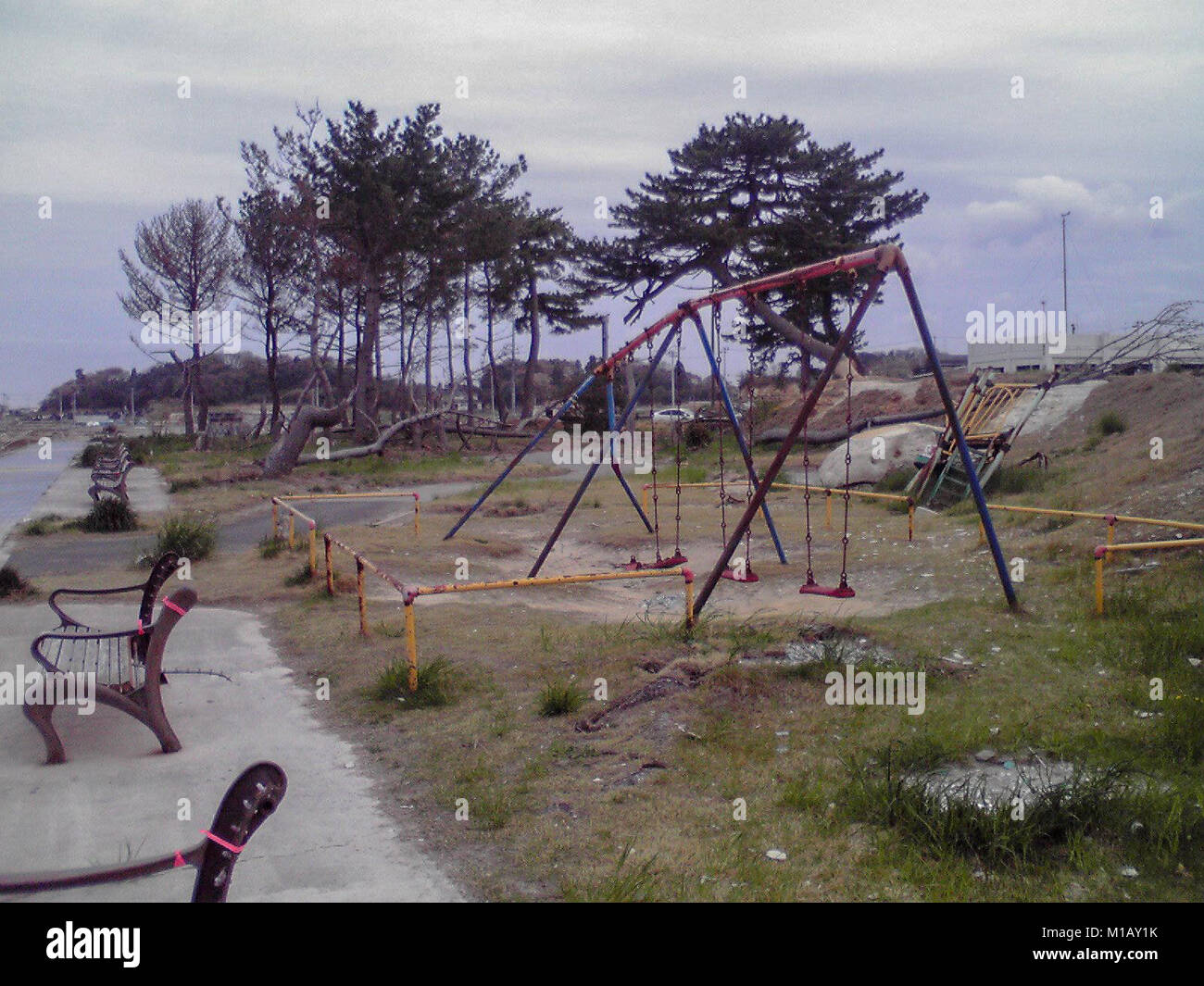 2 marzo 2012, Soma, Fukushima, Giappone. Quasi 1 anno dopo il Tohoku Earthquake-Tsunami disastro in Giappone. Il bagno pubblico in spiaggia Matsukawaura sinistra danneggiata dopo lo Tsunami come pure arrugginita Swing. Il quartiere residenziale di La spiaggia era danneggiato tuttavia adesso nel 2018 il frangiflutti è stato costruito lì. Foto Stock