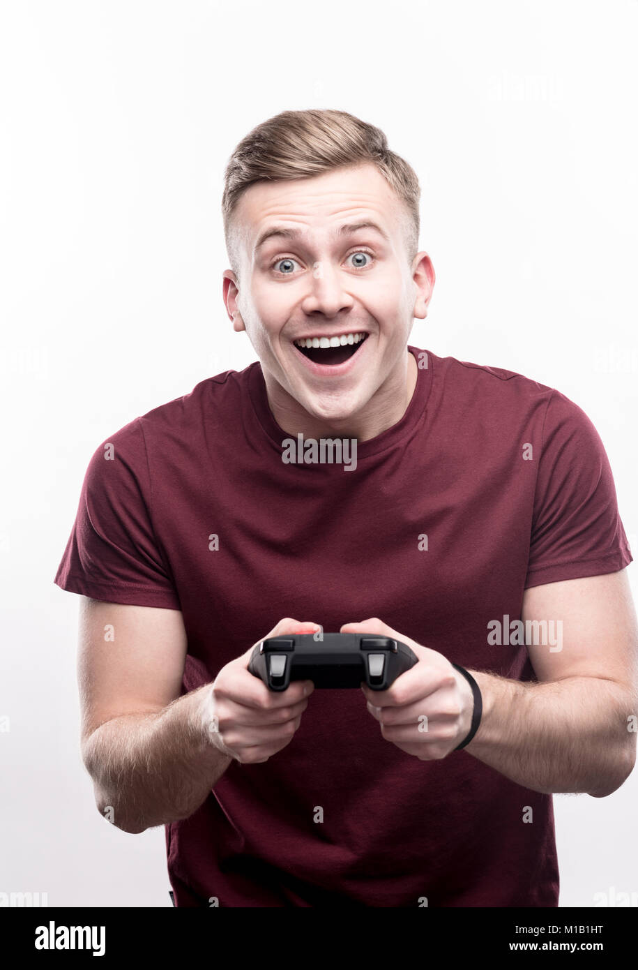 Upbeat biondo uomo vincente nel video gioco Foto Stock