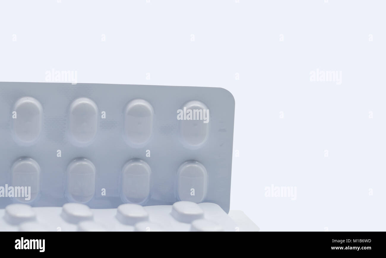 Macro shot dettaglio della pillola compresse in blister bianco pack per la resistenza alla luce imballaggio isolato su sfondo bianco. Medicina per il trattamento NCDs. Elde Foto Stock