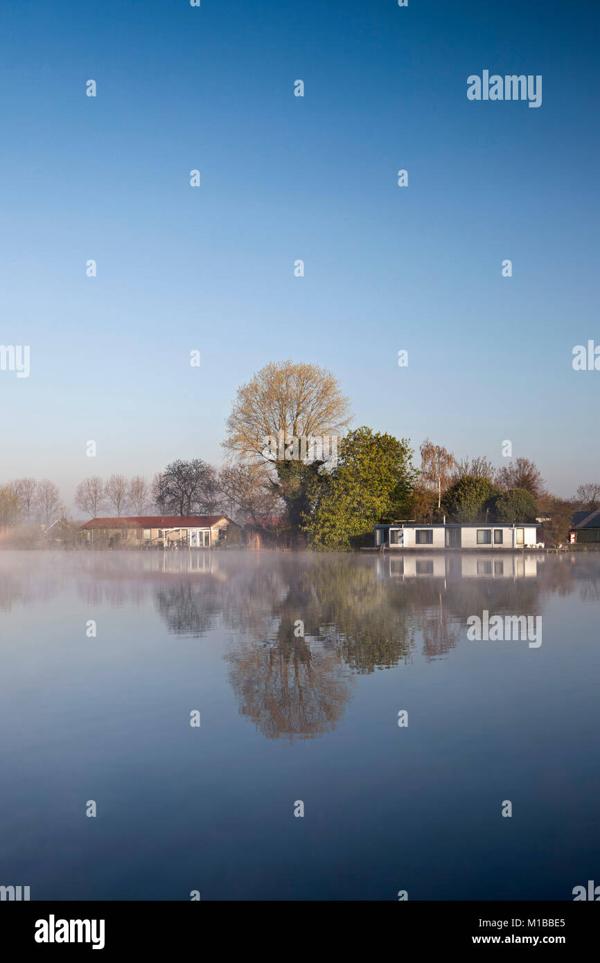 I Paesi Bassi, Weesp, Houseboats nel fiume chiamato Vecht nella nebbia di mattina a sunrise. Foto Stock