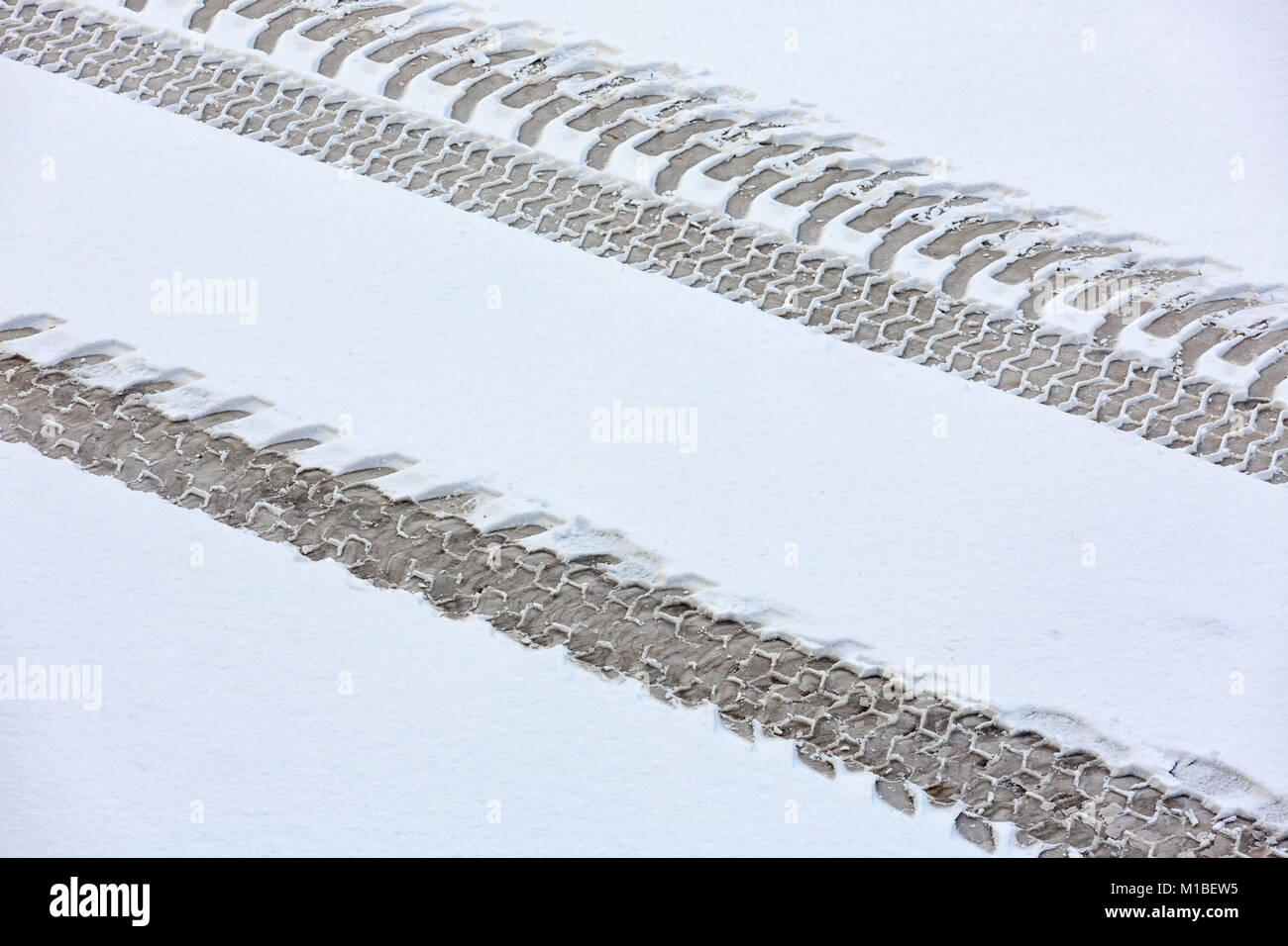 Tracce del trattore sulla coperta di neve su strada. Vista da sopra. Foto Stock