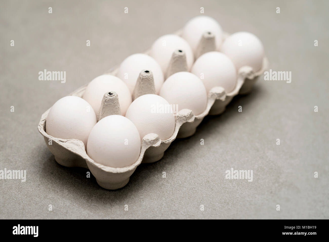 Dieci uova di gallina in confezione in cartone, diagonale. Concetto per Pasqua, uno stile di vita sano, vitamine e minerali, cibo organico, dieta, proteine e colesterolo Foto Stock