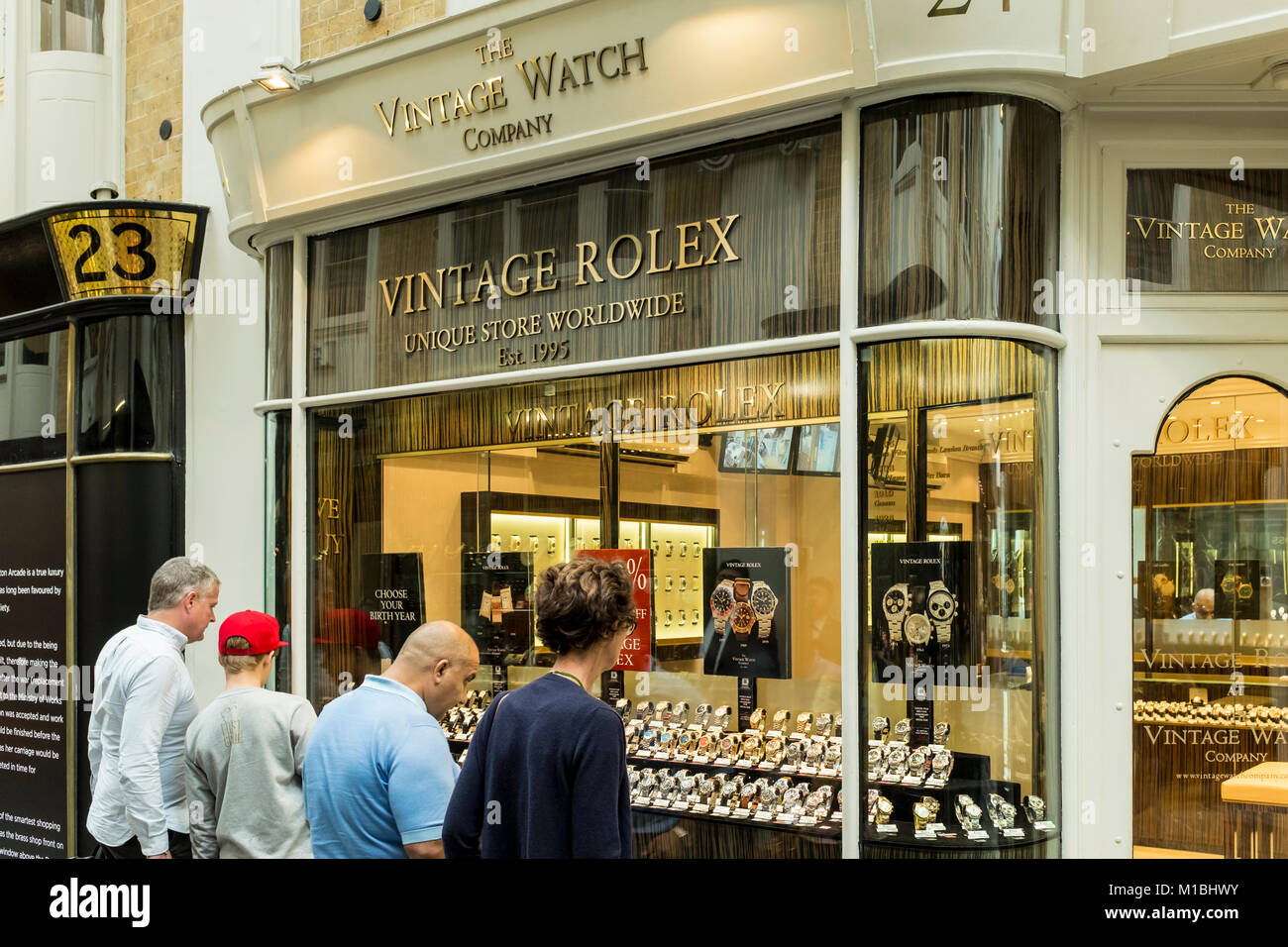 Persona guardando orologi vintage attraverso la finestra del negozio di Vintage Watch Company, Burlington Arcade, London, Regno Unito Foto Stock