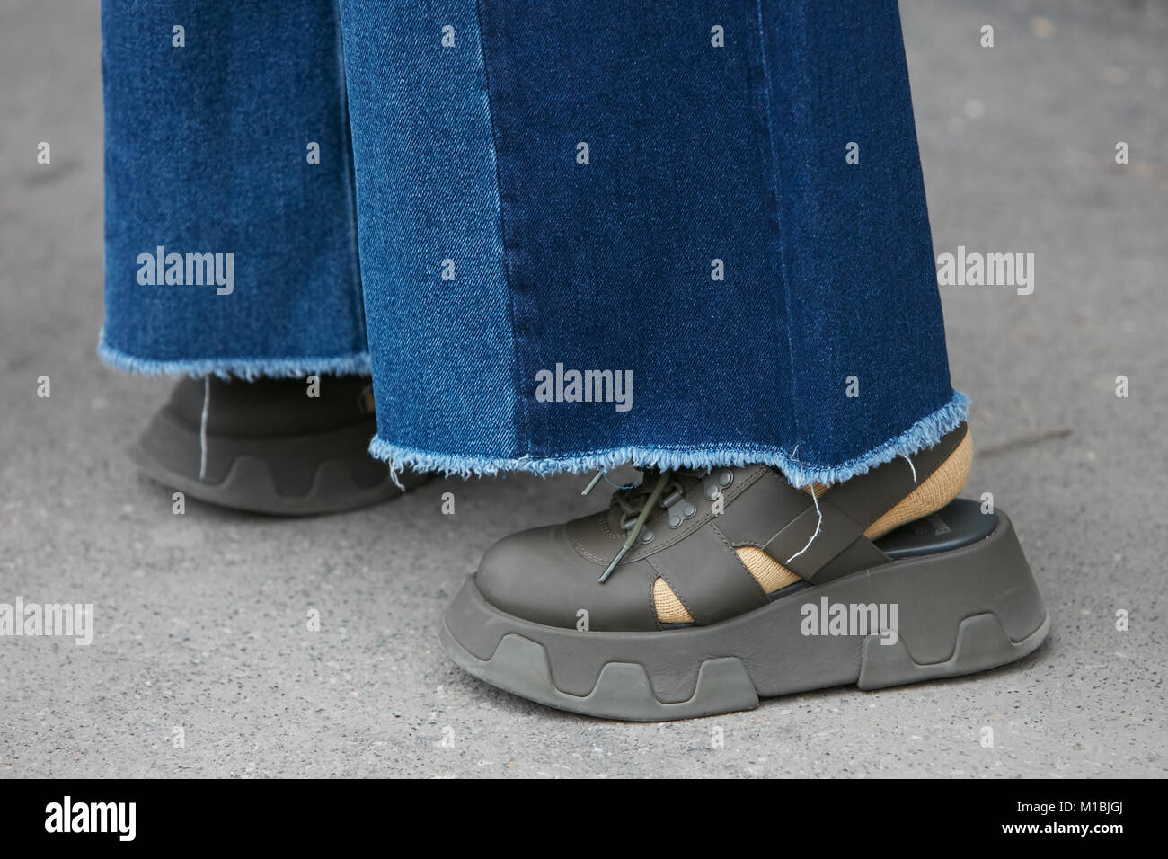 Milano - 15 gennaio: Donna verde con scarpe con tacco a cuneo e strappato jeans blu prima di Giorgio Armani fashion show, la Settimana della Moda Milanese street style Foto Stock