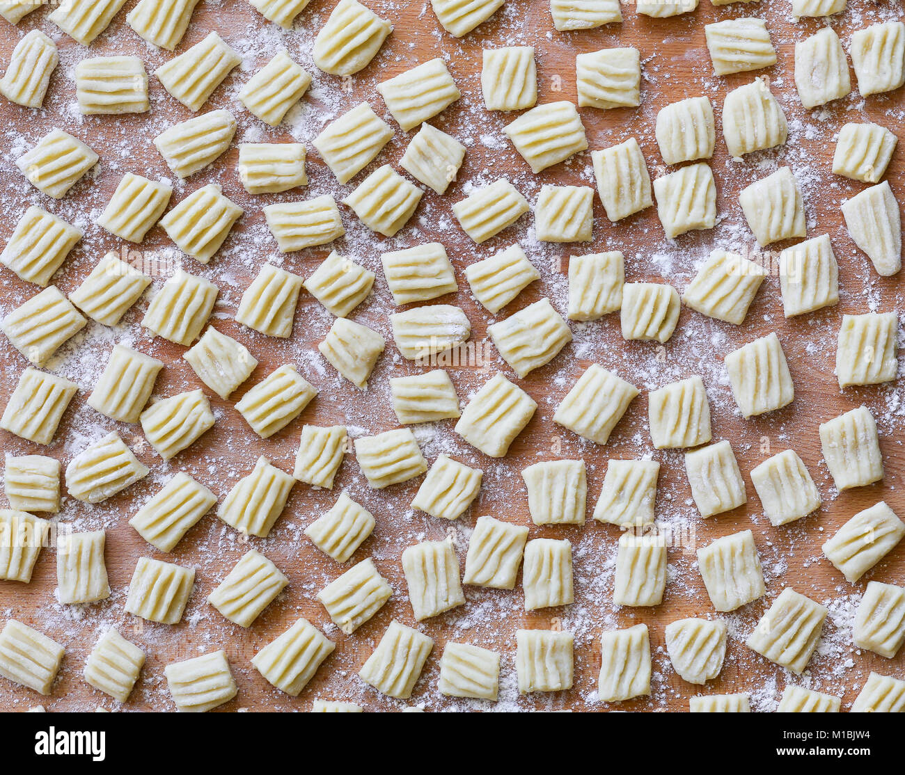 L'italiano non cotti di pasta fatta in casa gnocchi su pannello di legno Foto Stock