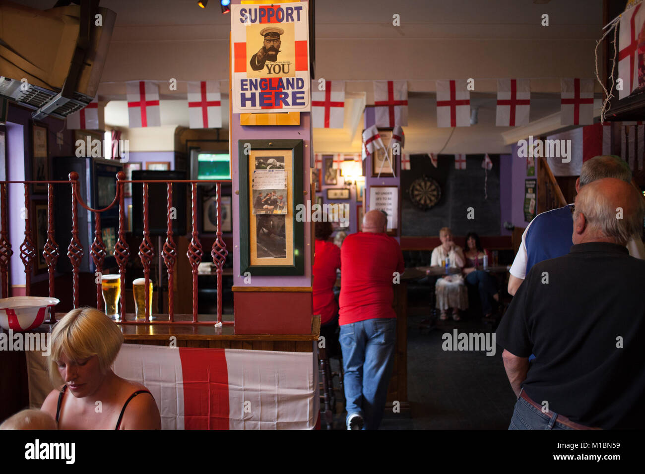 La gente del luogo al The Queens Head Pub, Burlslem, Stoke-on Trent, guarda l'Inghilterra World Cup match contro la Slovenia, 23 giugno 2010. Burslem era una volta la città madre della ceramica e ceramica industria, ma ora solo pochi della pentola le banche sono al funzionamento come la maggior parte del settore si è spostato verso l'estremo oriente. Ricco di fotografia di Bowen Foto Stock