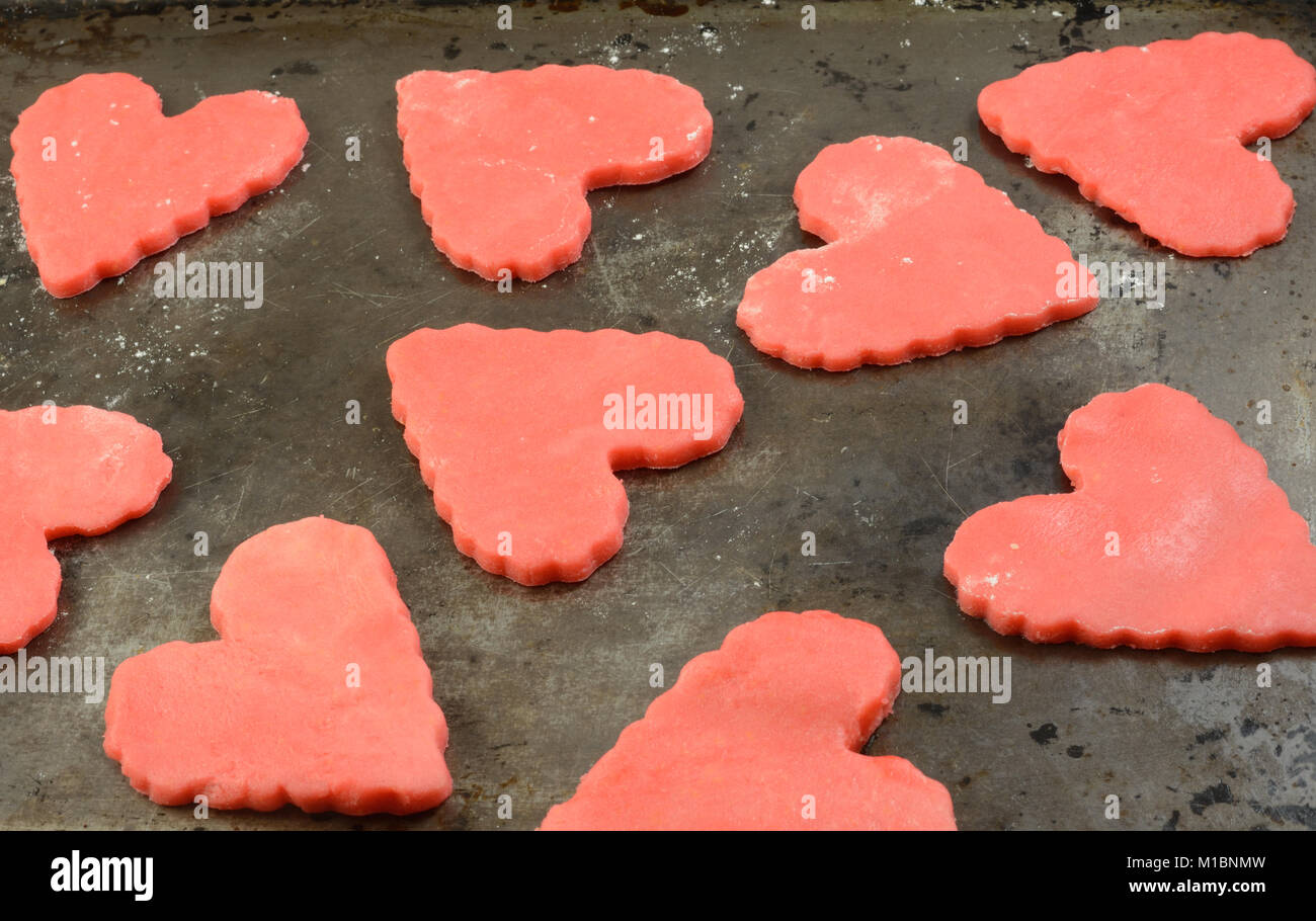 In prossimità delle materie di San Valentino Rossi cookies sulla teglia in preparazione per il giorno di San Valentino Foto Stock