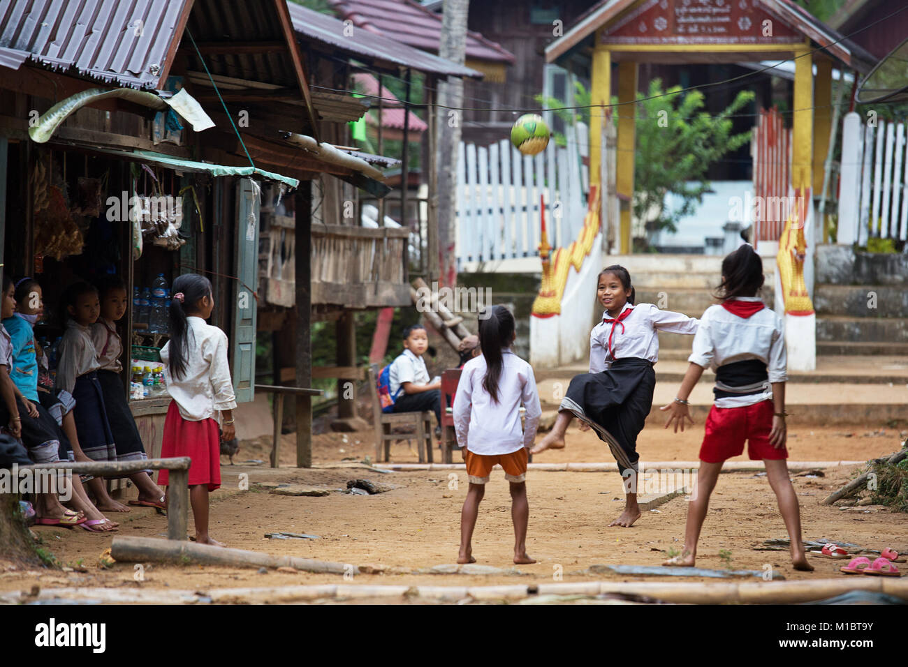 Le giovani ragazze a giocare a calcio in un villaggio prima dell inizio della scuola, Nord del Laos, sud-est asiatico Foto Stock