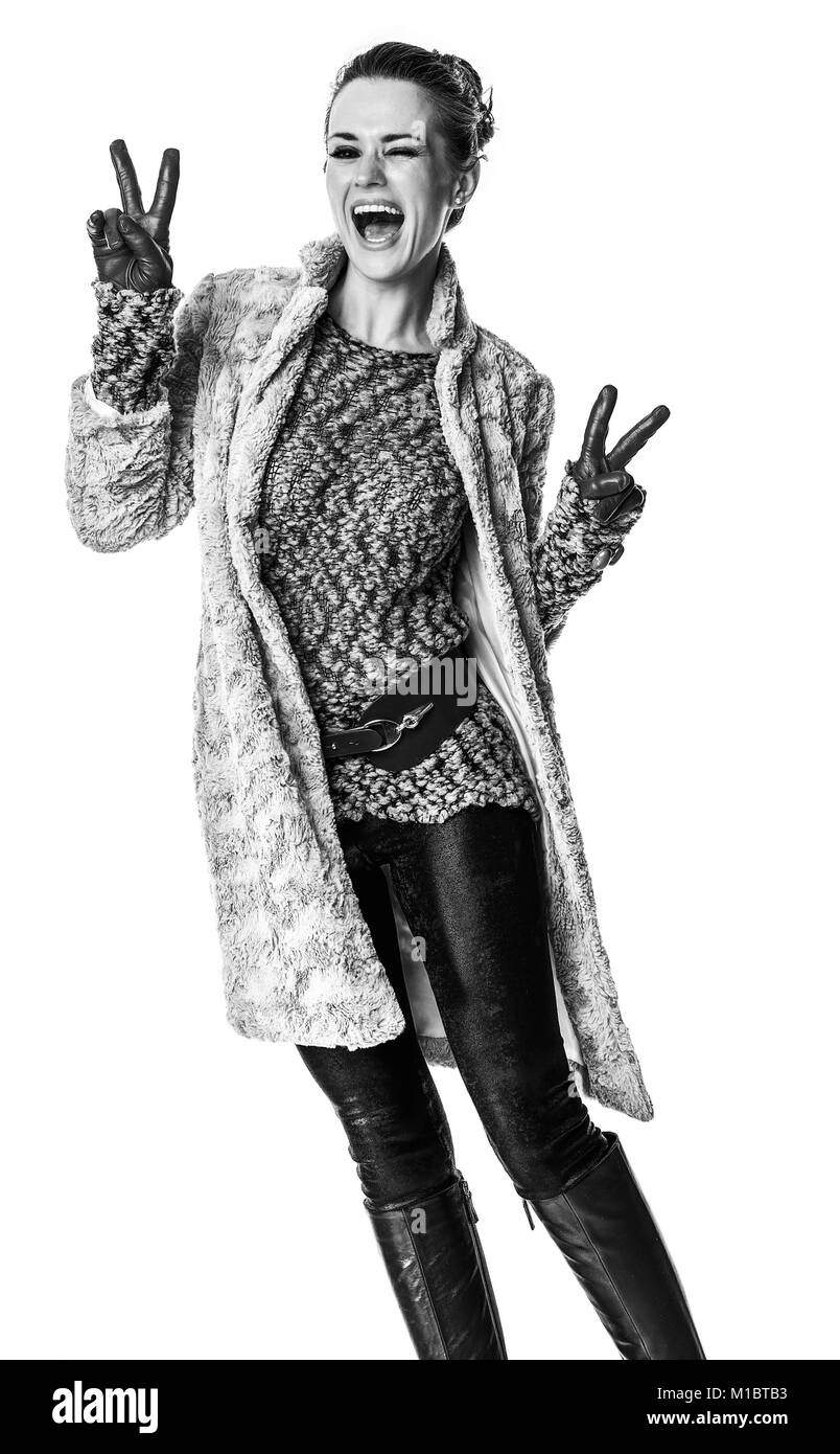 In inverno le cose. Felice moda giovane-monger in cappotto invernale isolati su sfondo bianco che mostra il gesto di vittoria Foto Stock