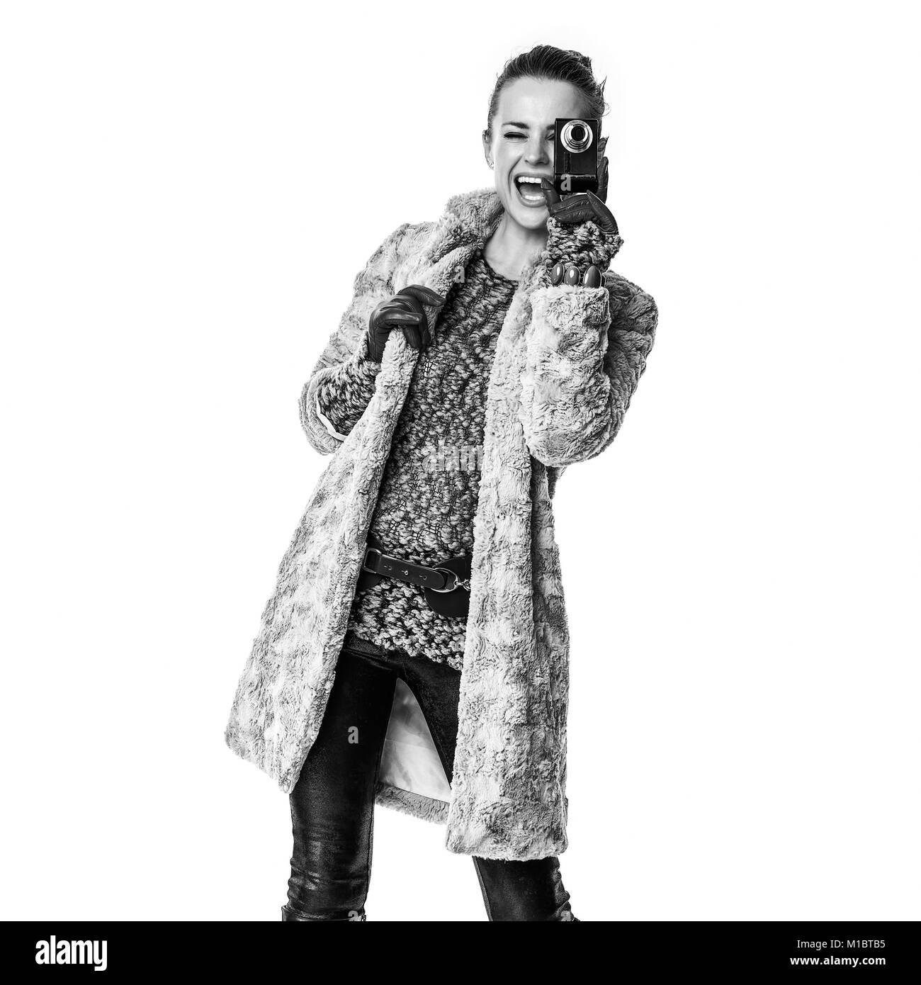 In inverno le cose. Felice donna moderna in cappotto invernale isolato su sfondo bianco con fotocamera digitale prendendo foto Foto Stock