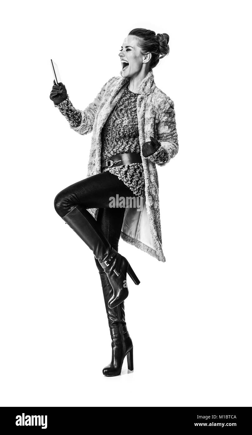 Cose d'inverno. A piena lunghezza Ritratto di sorridere alla moda donna in cappotto invernale isolato su bianco con tablet PC gioia Foto Stock