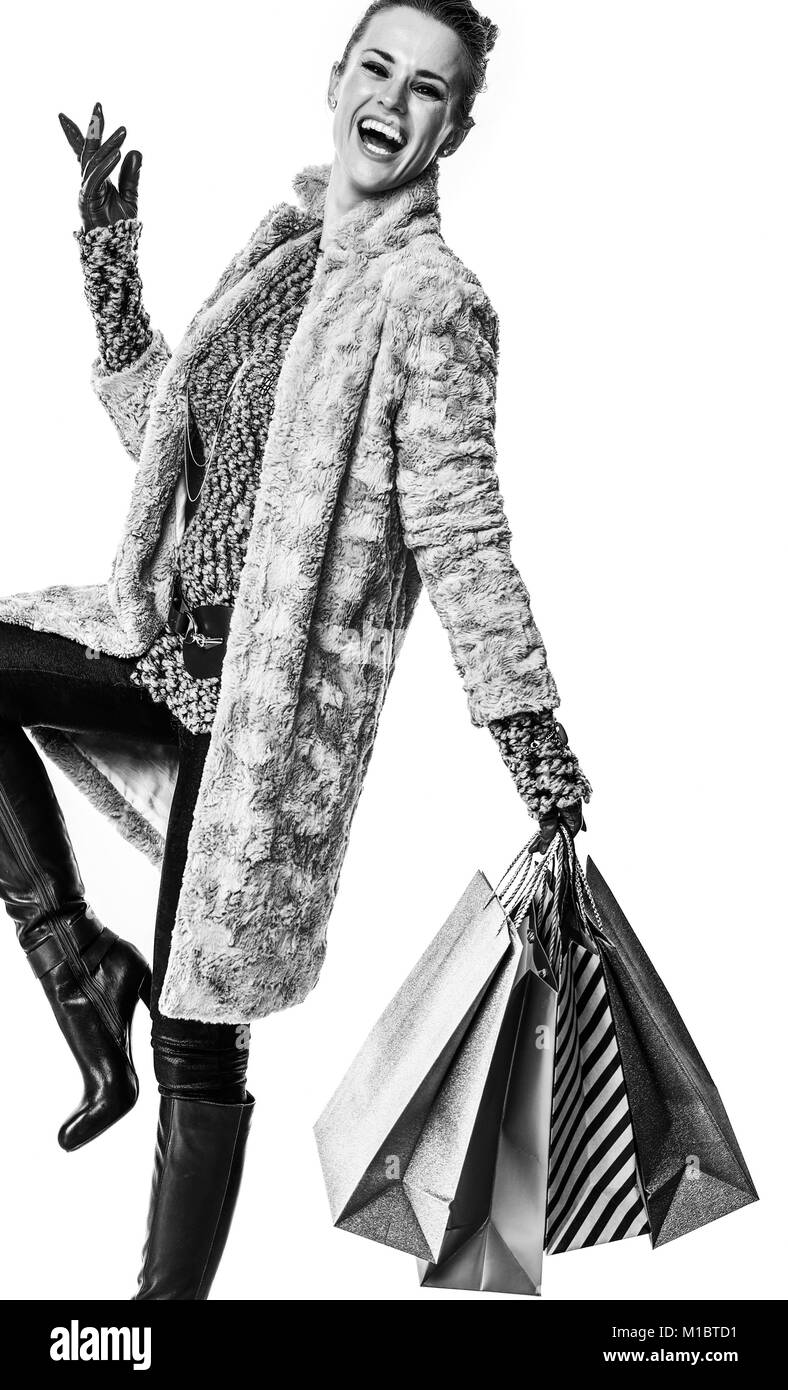 Cose d'inverno. A piena lunghezza Ritratto di sorridere elegante fashion-monger in cappotto invernale isolato su sfondo bianco con borse per lo shopping Foto Stock