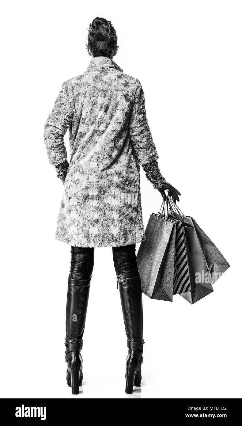 Cose d'inverno. Visto da dietro il giovane donna in cappotto invernale isolato su bianco con borse per lo shopping Foto Stock