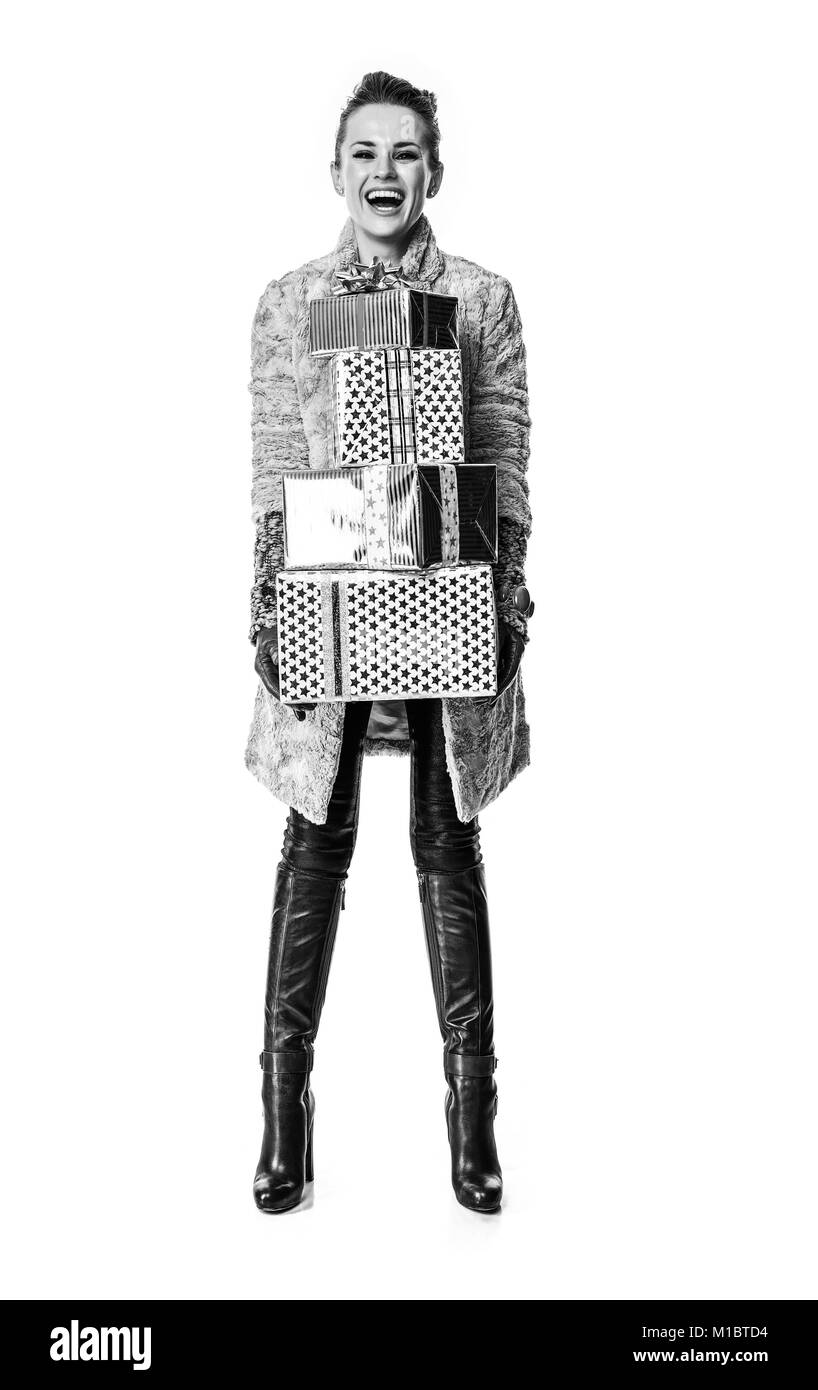 Cose d'inverno. A piena lunghezza Ritratto di felice moda giovane-monger in cappotto invernale isolato su bianco con pila di regalo di Natale scatole Foto Stock