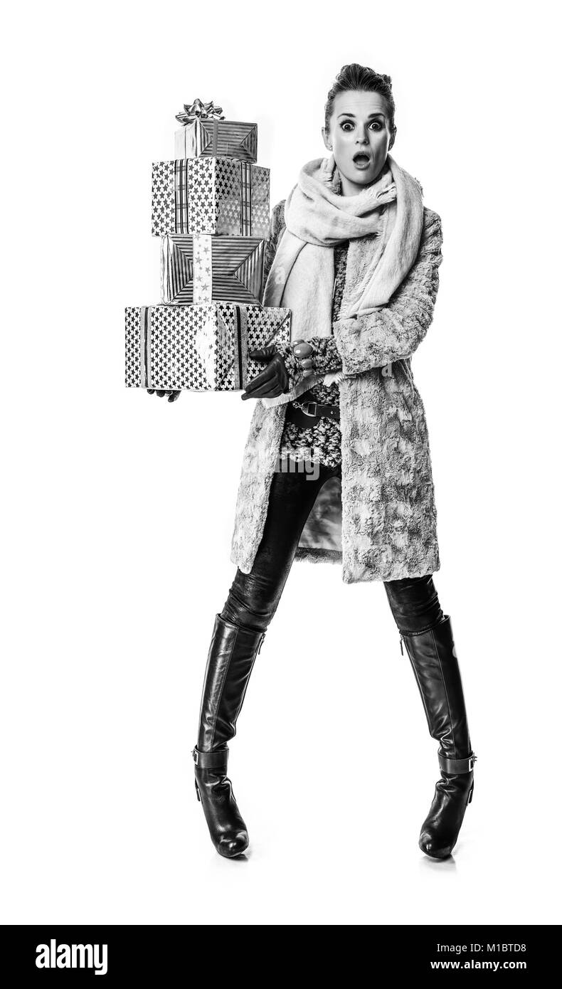 Cose d'inverno. A piena lunghezza Ritratto di sorpreso moderna moda-monger in cappotto invernale isolato su sfondo bianco con la pila di regalo di Natale boxe Foto Stock