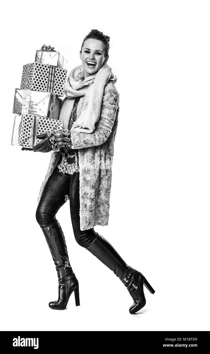 Cose d'inverno. A piena lunghezza Ritratto di sorridere moderna moda-monger in cappotto invernale isolato su bianco con palo di regalo di Natale a piedi le caselle Foto Stock