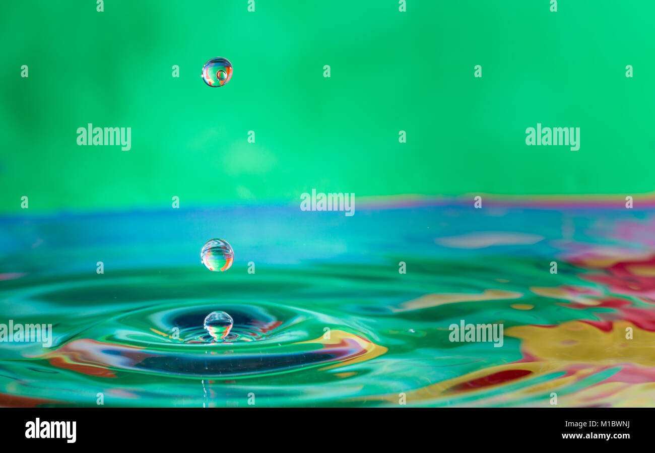 Close up di colorate le goccioline di acqua che rientrano Foto Stock