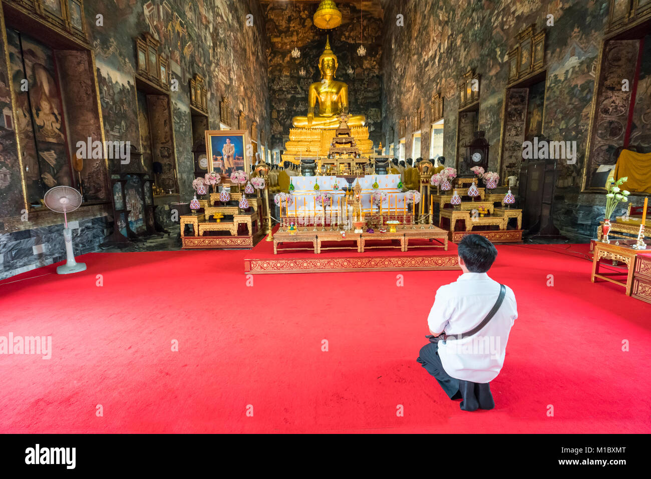 Un fedeli pregano in Wat Suthat tempio a Bangkok, in Thailandia Foto Stock