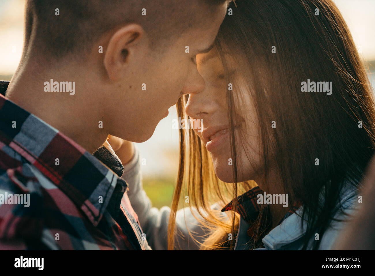 Romantico sensibile ritratto di allegro giovane in amore lo sfregamento dei nasi durante il tramonto. Foto Stock