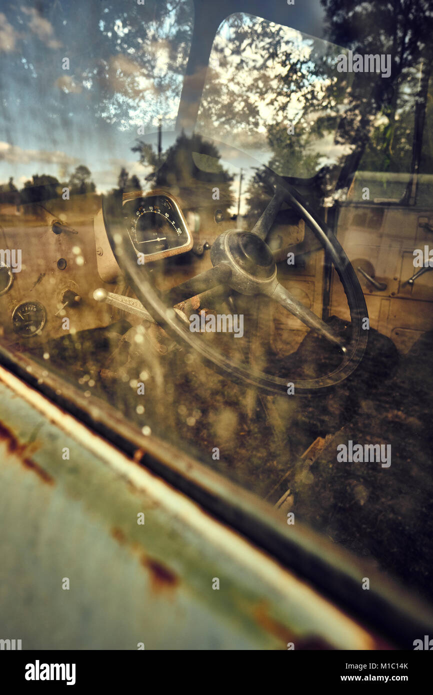 Una vecchia cabina di autocarro con il volante, il tachimetro e la finestra refllections Foto Stock