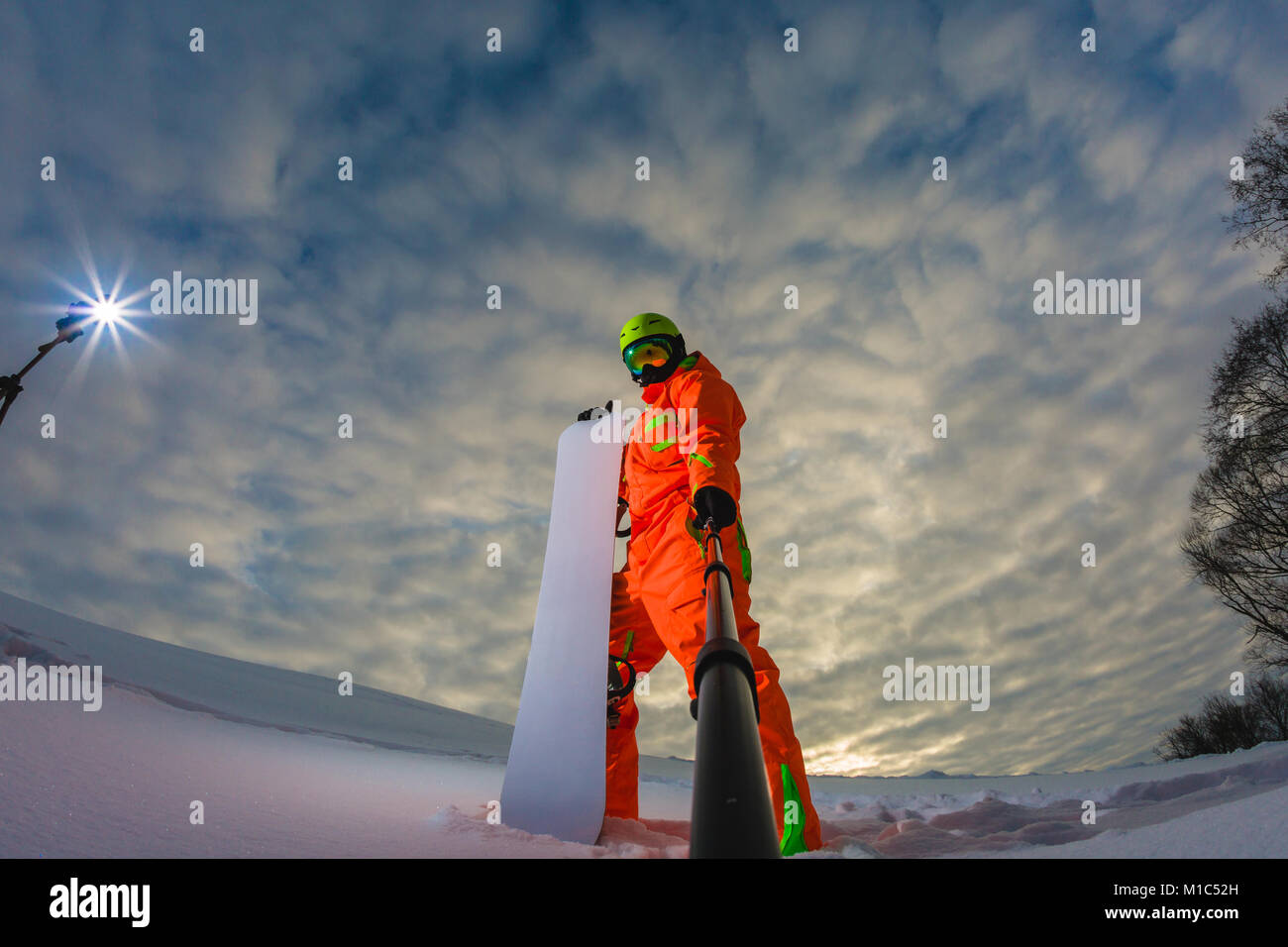 Snowboarder con lo snowboard facendo una selfie Foto Stock
